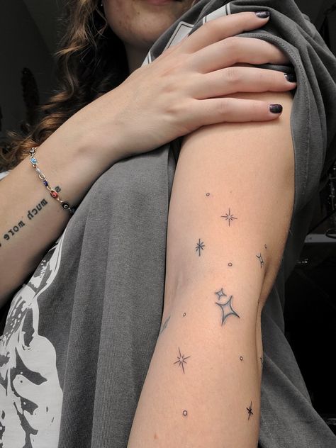 Star tattoo on arm Star Arm Wrap Tattoo, Star Patchwork Tattoos, Stars Around Moon Tattoo, Scattered Star Tattoos, Sparkle Tattoo Sleeve Filler, Star Tattoos Leg, Thigh Star Tattoo, Star Hip Tattoos Women, Star Arm Band Tattoo