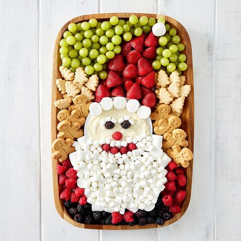 A wood food board decorated with fruit and cookies and marshmallows to look like Santa. Santa Charcuterie Board, Mid Winter Christmas, Sweets Board, Holiday Boards, Charcuterie Board Meats, Santa Snacks, Green Snacks, Christmas Platter, Christmas Trees For Kids