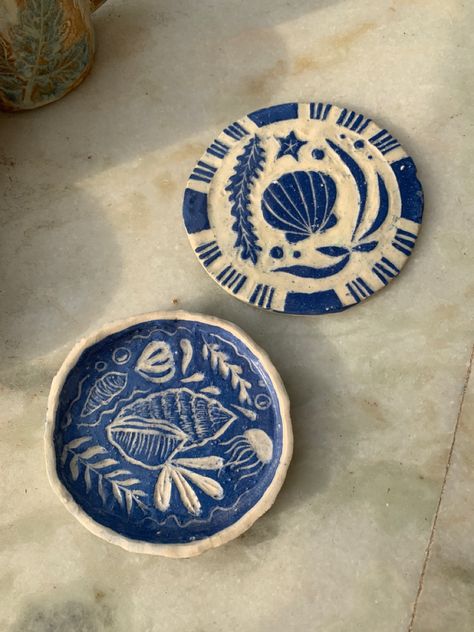 Made out of clay with sgraffito design Plate Carving Ideas, Carved Clay Designs, Clay Plate Design, Clay Coaster Designs, Seashell Pottery Painting, Sea Clay Art, Ceramics Plates Designs, Summer Clay Ideas, Clay Art Coasters