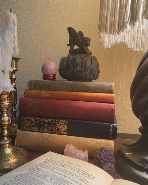 cozy desk set up of a bookstack of pretty vintage books, fairy trinkets, vintage candles, crystals, and a lamp on a desk Fairy Trinkets, Trinkets Vintage, Witchy Desk, Cozy Dark Academia, Fairy Academia, Whimsical Room, Candles Crystals, Witchy Room, Pretty Books