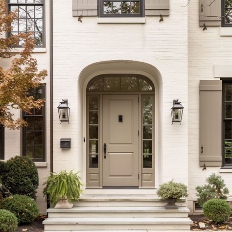 A welcoming porch with a solid wood door in warm earthy tones, surrounded by lush potted plants and a matching transom window Obscure Glass Front Door, White Brick House Front Door, Exterior Doors Farmhouse, Solid Front Door Ideas, Large Wood Front Door, Taupe Front Door, Shaker Front Door, Entry Flooring, Colonial Front Door