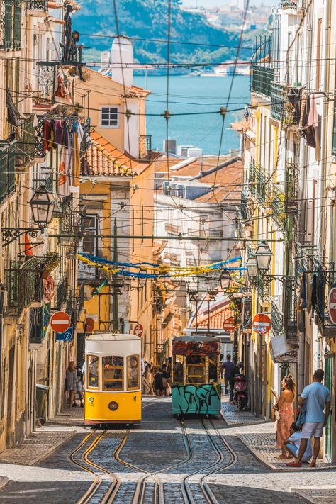 Lisbon has many stunning sites, but perhaps the best place to take it all in is along the city's famous Elevador da Bica. Pedestrians who walk (or ride) to the top of the steep incline will be greeted with dramatic views of the narrow street, cable cars running on their tracks, and further, the Tagus River. Many of the streetcars are painted by local street artists, adding more urban beauty and grittiness to the picturesque landmark. Capital Cities, Lisbon Travel, Sintra Portugal, Beautiful Streets, Voyage Europe, Portugal Travel, Famous Places, Lisbon Portugal, Best Cities