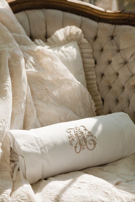 Intricate embroidery rendered in taupe on a crisp white bolster pillow plays off the earthen tones and carvedwood accents of this tufted-velvet settee. Bolster Pillow On Bed, Velvet Settee, Monogram Bedding, Home Decor Boards, Monogram Pillow, Victoria Magazine, Romantic Bed, Embroidery Pillow, Bolster Pillows