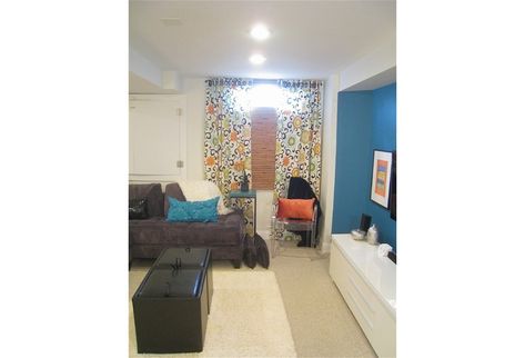 Hang long, colourful drapes over a tiny basement window (or no window at all). It'll create an optical illusion that makes it look as though there's a large window behind it. Basement Window Coverings, Basement Window Treatments, False Window, Closet Window, Family Basement, Teen Basement, Small Basement Design, Transitional Basement, Basement Window