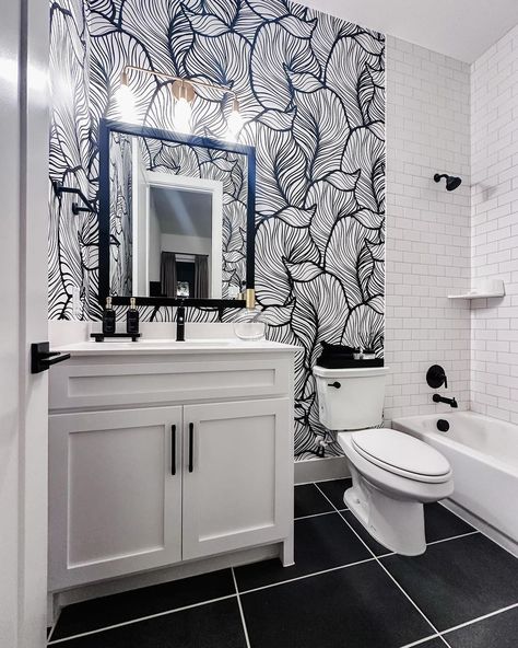 We’re falling head over heels for this stunning black and white bathroom! The bold leaf-printed accent wall adds a touch of drama and elegance, making this space truly pop. 🍃🌿 What’s your favorite way to use wallpaper in your home? Share your thoughts below! 📷 @virtu_interiors_llc . . #wallpaperwednesday #neutralbathroom #blackandwhitebathroom #thepolishedjar #polishedjar #moderndecor #interiordesignblogger #interiordesigner #interiordesignideas #smallbusinessowner #beauty #soapdispenser... Half Bath Black And White, Black And White Wallpaper Bathroom, Black And White Half Bath, White Bathroom With Wallpaper, Black And White Rooms, Bold Bathroom Wallpaper, Bathroom With Wallpaper, Wallpaper Accent Wall Bathroom, Bold Bathroom