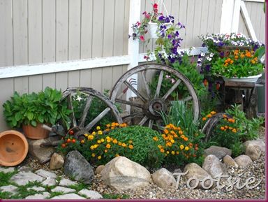 love the wagon wheels Wagon Wheel Garden, Ranch Entrance, Rustic Landscaping, Backyard Gardens, Country Garden Decor, Farmhouse Landscaping, Garden Junk, Flower Gardens, Garden Yard Ideas