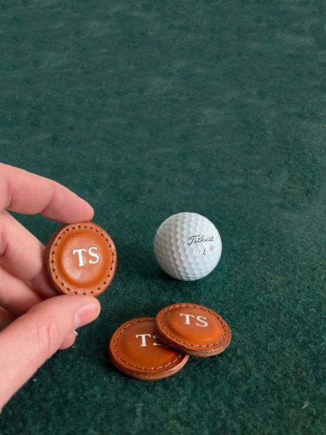 Give your favorite golfer a gift they’ll cherish with these classic leather Golf Ball Markers, handmade in the USA from high-quality full-grain vegetable-tanned leather. This set of two beautifully crafted markers features fine stitching and edge finishing, offering a luxurious touch to the golf course. Each marker can be personalized with a 2-letter monogram, making it a thoughtful and unique gift for any golf lover. These durable and stylish markers are perfect for use on the green, and their Golf Leather Goods, Leather Golf Accessories, Random Golf Club, Personalized Diy Gifts, Favorite Things Gift Ideas, Gifts For Boss Male, Fitness Gifts For Men, Luxury Corporate Gifts, Female Cow