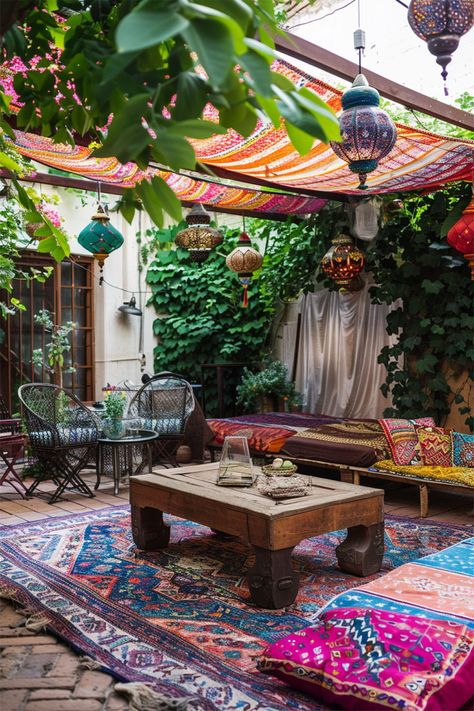 The image features a cozy and vibrant patio setup with a bohemian theme. The space is adorned with colorful textiles and fabrics draped overhead, creating a shaded area. Various lanterns hang from the wooden pergola, adding an eclectic and warm touch to the ambiance. The patio is furnished with a mix of comfortable seating options, including chairs and cushions, and a central table. Patio Shade Diy, Patio Shade Ideas, Eclectic Garden, Easy Patio, Shade Ideas, Cozy Patio, Diy Shades, Patio Shade, Bedroom Retreat