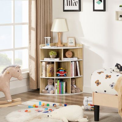 This small bookcase turns an empty corner into a functional storage and display space. It's crafted from engineered wood in a neutral hue that goes with a variety of color schemes. The design features three tiers of open shelf compartments great for books, decor, toys, and more. We love that the top is big enough for a table lamp or vase, as well as a warm beverage. Plus, this petite corner bookcase is also scratch- and chip-resistant for holding up to everyday use. Color: Marble White | Wade Lo Book Shelf For Baby Nursery, Nursery Room Bookshelf Ideas, Book Shelves Nursery, Nursery Bookshelf Ideas, Wooden Cube Storage, Nursery Toy Storage, Nursery Book Storage, Nursery Bookcase, Cube Storage Organizer