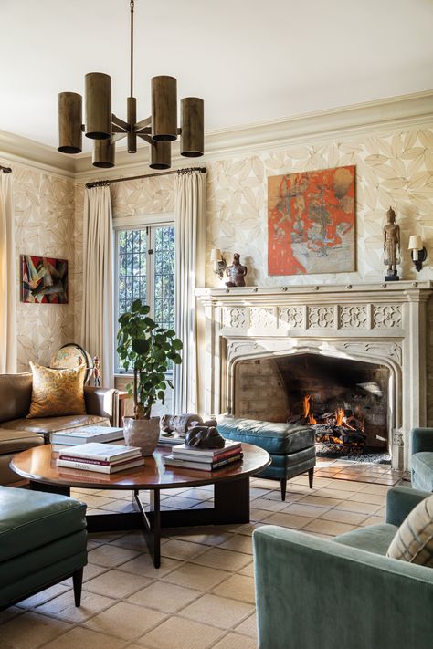 An original fireplace in the downstairs den makes for a cozy gathering space for Ward and his family. The room is furnished with a vintage chandelier from Carlos Castañeda Antique Hardware and a painting by J. Parker Valentine above the fireplace. Hamptons Farmhouse, Spanish Modern, Tudor Style Homes, Caribbean Style, Colonial Design, Active Family, Treasure Coast, Florida Style, Colorado Mountain