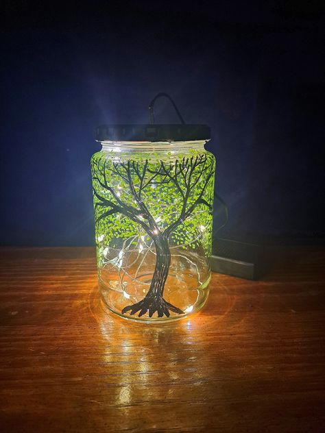 Perfect for virtually any style of living room, bedroom, or dorm, this handmade fairy light lamp is created with upcycled glass and oil-based paint. It's even perfect for a guy! Features a hand-painted green leafy tree with curling tendrils backlit by ambient fairy lights to set a dreamy mood in your living space! Because the art is hand-drawn, each jar is unique and no two are exactly alike.  Because they are crafted from upcycled materials, the jars I use may vary in brand, style, and sizing.