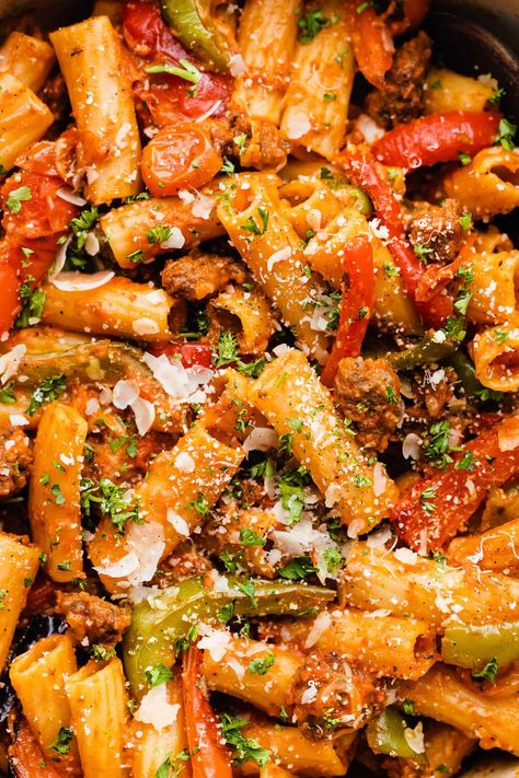 This pasta dish is one of our all-time favorite weeknight meals! It's made with plenty of roasted bell peppers and tomatoes, with some getting blended into a sauce for extra heartiness. Toss your veggies and rigatoni together with plenty of sausage, sauce, and parmesan cheese for an easy and impressive dinner everyone will love! #rigatoni #weeknightpasta #roastedredpeppers #bellpeppers #italiansausage #easydinnerrecipes #mealpreprecipes #bluebowlrecipes | bluebowlrecipes.com Rigatoni Sausage, Bell Pepper Pasta, Rigatoni Pasta Recipes, Burst Tomatoes, Roasted Bell Peppers, Sausage Parmesan, Rigatoni Recipes, Sausage Sauce, Roasted Vegetable Pasta