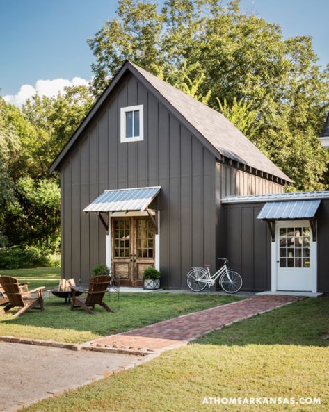 Gray-brown board and batten, white door/window trim, and stained wood accents, from At Home Arkansas. Metal Buildings With Living Quarters, Board And Batten Exterior, Farmhouse Exterior Design, Metal Building Home, Gray House, Board And Batten Siding, Young House Love, Unique Farmhouse, Casas Coloniales