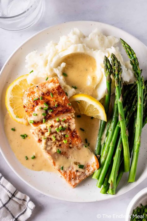 This creamy lemon garlic salmon is so seriously indulgent! Seasoned to perfection, poached in the most luscious lemony creamy sauce, and whipped up in just 20 minutes. #theendlessmeal #salmon #lemonsalmon #dinner Salmon Plating, Cream Sauce For Salmon, Salmon With Cream Sauce, Lemon Garlic Salmon, Lemon Dill Sauce, Fish Dinners, New Healthy Recipes, Lemon Cream Sauces, Sauce For Salmon