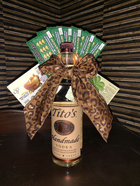 I made this for a raffle item. Tito’s vodka, 10 $1 lottery tickets hot glued together with 2 $2 tickets on each side. Then hot glued that to the back and tied leopard wired ribbon into a bow! Prize Basket For Men, Guys Raffle Basket Ideas, Alcoholic Basket Ideas, Lottery Raffle Basket, Tito’s Gift Basket, Wine Bottle Raffle Basket Ideas, Titos Vodka Gift Basket Ideas, Popular Raffle Basket Ideas, Lottery Ticket Gift Basket