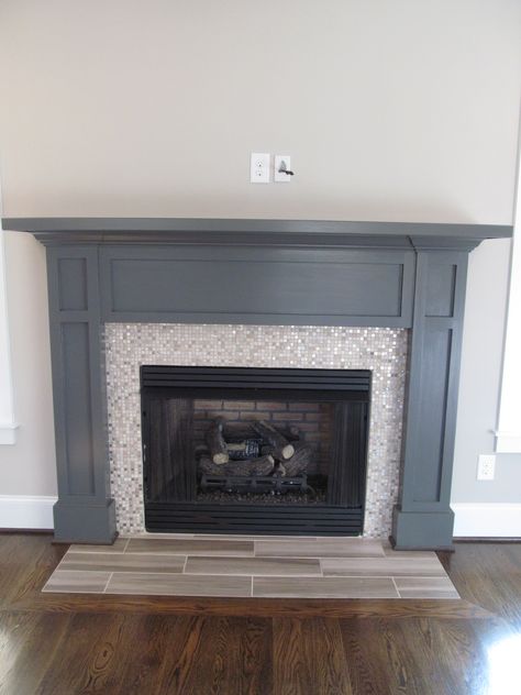 Painted the mantle dark gray to match the interior doors.  It made the tile surround really pop. Dark Grey Mantle, Dark Blue Fireplace Mantle, Dark Painted Fireplace, Fireplace Surround Diy, Painted Fireplaces, Paint Fireplace Tile, Painted Fireplace Mantels, Tile Around Fireplace, Painted Mantle