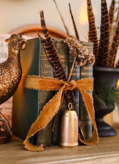 green vintage books tied with a velvet ribbon Fall 2023 Vintage, Anthropology Decor Inspiration, Fall Decor With Pheasants, Vintage New Years Decor, Historic Home Fall Decor, Decorating With Pheasants For Fall, Velvet Fall Decor, Decorating With Pheasant Feathers, Fall Pheasant Decor