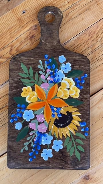 Paintings by Mary on Instagram: "Can you spot the little differences between this on and the 1st? I made 4 boards that are all coordinated but different. I’m saving my favorite for last. #custom charcuterie board #paintingsbyMARY #myobsession #artistshop #woodtray #cuttingboard #woodtray #floralpainting #artisttowatch #lily #giftgiving #mesmerizingmoments" Charcuterie Board Art, Painted Charcuterie Board, Wooden Platters, Mexican Home Decor, Painted Boards, Paint Marker, Acrylic Painting Techniques, Paint And Sip, Craft Night