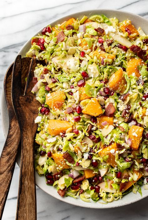 Need something fresh for Thanksgiving? Give this shaved Brussels sprouts salad a try. It's got bacon, butternut squash, pomegranates, cheese, almonds, and it's tasty and easy to customize. Shaved Brussel Sprout Salad Butternut Squash, Thanksgiving Salad Recipes, Shaved Brussel Sprout Salad, Shaved Brussel Sprouts, Thanksgiving Salad, Autumn Salad Recipes, Sprouts Salad, Squash Salad, Hearty Salads