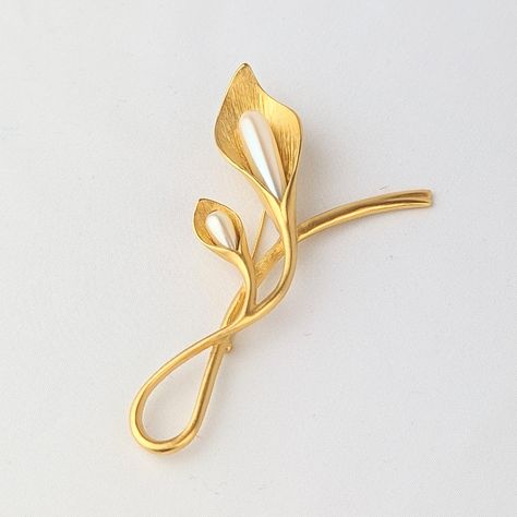 Gorgeous large 4" vintage calla lily flower brooch made in gold-tone metal. The two blooms on the lily flower are made of faux pearls. The pin is in excellent vintage condition. Secure c-clasp pin backing. Signed by jewelry designer Piscitelli. Perfect as a sash pin, to accent an outdoor dress jacket, or an elegant accessory for a formal event. A classic wedding jewelry accent piece would also make a thoughtful gift. Gift worthy. Display worthy. -------------------------------------------------- Calla Lily Jewelry, Calla Lily Flower, Lily Jewelry, Outdoor Dress, Dress Jacket, Elegant Accessories, Classic Wedding, Lily Flower, Jewelry Designer