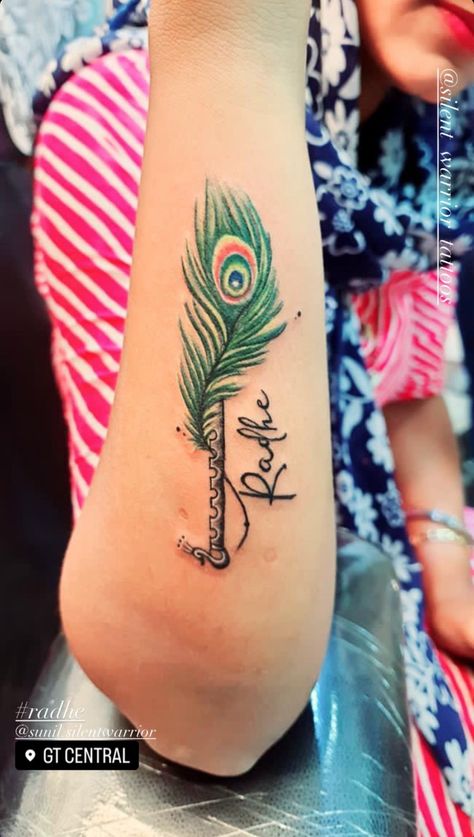 Visit silent warrior tattoos #jaipur to get inked. #peacockfeather #tattoo #colorful #flute #radhe #tattooidead #fashion #tattoodesign #tattooart Radhe Radhe Tattoo Design, Flute With Feather Tattoo Designs, Radhe Radhe Tattoo, Peacock Feather With Flute, Silent Warrior, Flute Tattoo, Tattoo Colorful, Colorful Peacock, Feather Tattoo Design