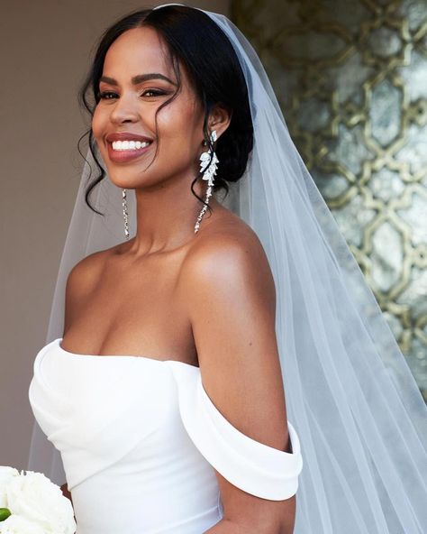 Sabrina Dhowre Elba's wedding hairstyle is the perfect mix of polished and undone. The model pulled her tresses back into a curled chignon, but she added details to make the hairdo feel more fresh. For example, she parted her hair down the center and pulled two pieces out in front. For a unique twist, she rocked a veil on one side of her head. From minimalist up-dos to glamorous waves, we have hair inspo ahead for every kind of to-be-wed. See our favorite celebrity wedding hairstyles, here. Wedding Hair 4c, Natural Curly Hair Wedding Styles With Veil, Low Bun Wedding Hair Black Women, Bridal Hair Updo Black Women, Black Wedding Hairstyles For Bride, Medium Bridal Hair, Natural Wedding Hairstyles Black Bride, Wedding Makeup Black Women, Bridal Hair Black Women