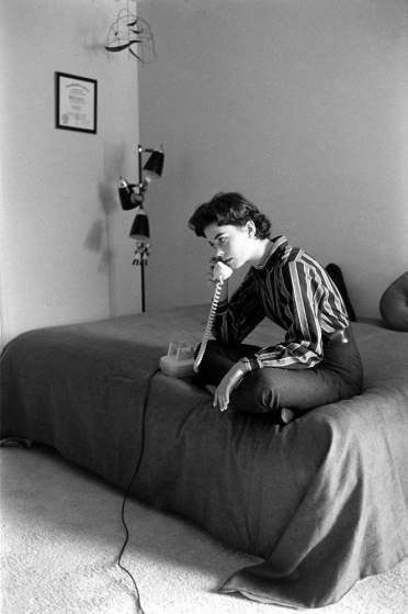 Natalie Wood takes a call while sitting on her bed at home in 1956. Someone Sitting On A Bed Reference, Sitting Upside Down On Couch, Poses With Furniture, Sitting Up In Bed Reference, Sitting In Bed Pose, Sitting On Bed Pose, Person On Phone, Bed Reference, Bed Pose