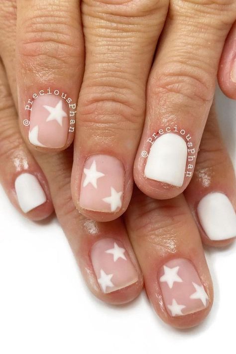 These short, neatly shaped nails are a subtle nod to elegance with a playful twist. A soft white hue dominates, presenting a clean and crisp canvas, while select nails showcase a dreamy, translucent pink base decorated with delicate white stars. The look achieves a harmonious balance between simplicity and charm, perfect for a serene yet festive celebration.  // Photo Credit: Instagram @preciousphan Star Nail Designs, Patriotic Nails, Festive Nail Designs, Minimalist Nail, Fourth Of July Nails, Short Gel Nails, 4th Of July Nails, Short Square Nails, Simple Gel Nails