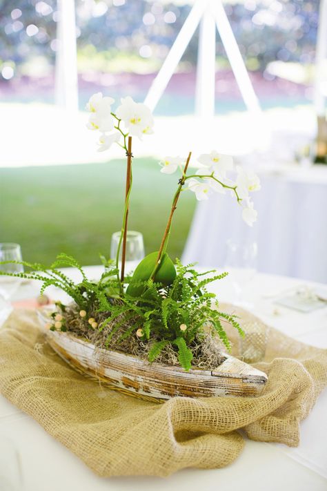 Boat-Themed Centerpiece Boat Wedding Centerpieces, Canoe Centerpiece, Orchid Beach Wedding, Boat Centerpiece Ideas, Fishing Centerpieces, Lake Party Decorations, Fishing Centerpieces Ideas, Boat Wedding Decorations, Boat Centerpieces