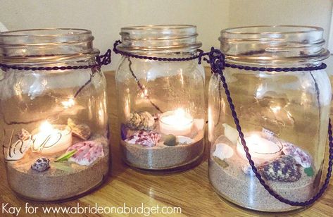 Are you planning your beach wedding but have NO IDEA what to do for centerpieces? Don't worry! These beach wedding mason jar centerpieces are the answer. Plus, they're PRETTY and EASY! Head to www.abrideonabudget.com for the tutorial. Wedding Mason Jar Centerpieces, Wedding Centerpieces Beach, Beach Mason Jars, Diy Wedding Centerpieces, Wedding Centerpieces Mason Jars, Beach Wedding Decorations Reception, Frugal Wedding, Beach Wedding Centerpieces, Simple Wedding Centerpieces