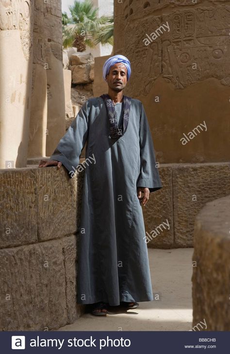 Download this stock image: Nubian man wearing traditional clothing, standing between columns, Karnak Temple, Luxor, Egypt, Africa - BB8CHB from Alamy's library of millions of high resolution stock photos, illustrations and vectors. Egyptian Clothing Men, Egypt Clothing, Ancient Egyptian Clothing, Elizabeth Peters, Egyptian Men, Egyptian Clothing, Egypt Culture, Karnak Temple, Luxor Egypt