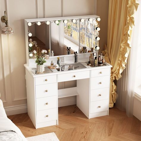 PRICES MAY VARY. Adjustable Mirrors & Hidden Storage - This makeup vanity desk features a large and high-definition mirror that is divided into 3 parts. The mirrors on either side can be opened and adjusted in angle, which will reflect your beauty from different angles and meet your makeup needs. And there are hidden storage shelves behind the 2 side mirrors. Glass Desktop - The vanity desk possesses a spacious glass desktop and 9 drawers to store your cosmetics. The 43.3 inch glass desktop can Dorm Room Vanity Desk, Makeup Vanity With Drawers, Cushion Stool, Vanity Desk With Mirror, Desk With Mirror, Makeup Vanity Desk, Bulb Lights, Hidden Shelf, Mirrored Vanity Desk