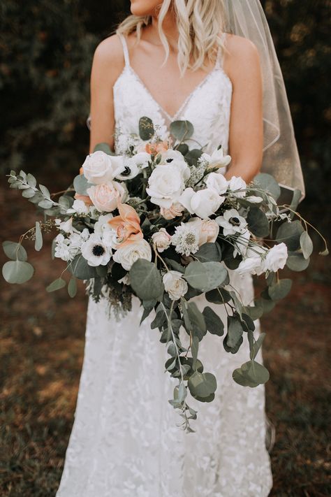 Taking place at a rustic barn venue, this bride and groom planned a picture perfect outdoor fall wedding. If you and your partner are planning a cool weather wedding, enjoy the great outdoors, and have a love for classic & romantic details, Kylie & Tyler’s autumn nuptials might be the perfect inspiration for you. Visit rusticweddingchic.com for more real wedding inspiration! | Photo: @christimphoto Venue: @sainte_terre Cascading Bridal Bouquets Eucalyptus, Cascading Wedding Bouquets Summer, Olive Green Bouquet, Bride Bouquet Eucalyptus, White Scabiosa, Outdoor Chapel, Eucalyptus Wedding Bouquet, Cymbidium Orchid, Dusty Peach