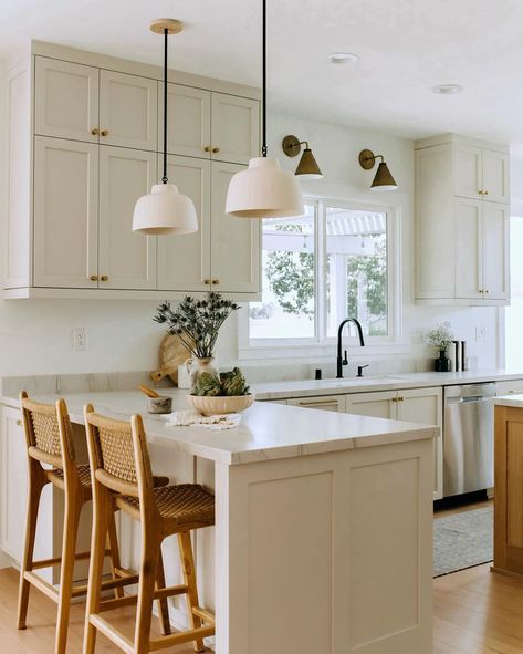 If you have an L-shaped kitchen or a kitchen peninsula, let this kitchen design by @highandtightdesign serve as inspiration for your space. We love the mix and match light fixtures, light neutral kitchen paint color, and woven rattan counter stools. Small Kitchen With Peninsula And Island, Open Kitchen Into Dining Room, Island In Breakfast Nook, Kitchen Peninsula With Upper Cabinets, Kitchen Peninsula Before And After, Kitchen With Peninsula Seating, L Shaped Kitchen Counter With Seating, L Counter Kitchen, Gallery Kitchen With Peninsula