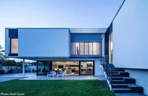 The facade of the modern house, painted in white and cladded with concrete strips, emphasize it’s horizontal direction. Iron slats provide shading and add to the sense of rhythm. Designed by Jacobs Yaniv Architects, photo by Amit Geron - Fineshmaker 200sqm House, House Luxury Modern, Modern House Philippines, Modern Facades, Ideas For House, Paint For Kitchen Walls, Home Gym Design Garage, Concrete Facade, Courtyard House Plans