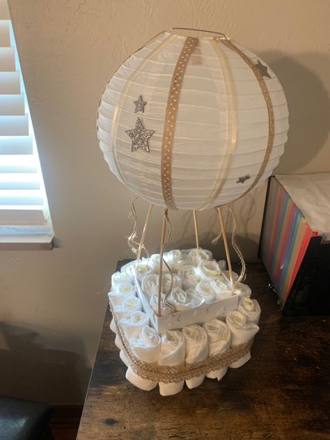 Super easy hot air balloon diaper cake! Hot Air Balloon Baby Shower Gift, Hot Air Balloon Diaper Cake, Work Baby Showers, Gender Neutral Baby Shower Themes, Diy Diaper Cake, Baby Shower Safari Theme, Baby Shower Gift Box, Hot Air Balloon Decorations