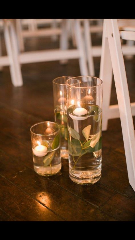 Submerged eucalyptus - floating candles down the aisle  The Flour Mill, McKinney, TX Floating Candle And Eucalyptus Centerpieces, Eucalyptus And Floating Candles Centerpiece, Floating Candle Isle, Floating Candle Centerpieces Eucalyptus, Floating Candle Aisle, Cylinder Vases With Floating Candles And Greenery, Candle Centerpieces Wedding, Floating Candle Water Beacs, Aisle Candles