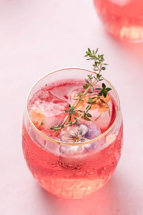 A simple, refreshing, and pretty Pink Lemonade Cocktail. Made with cranberry juice, Malibu, and some fizz to give you a go-to cocktail. Cocktails With Edible Flowers, Cocktail With Flowers, Drinks With Edible Flowers, Fun Pink Cocktails, Petals And Prosecco Theme Outfit, Bridgerton Themed Cocktails, Cocktail Party Food Elegant, Pink Cocktail Ideas, Drinks With Flowers