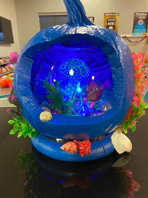 Pumpkin painted blue with one side carved out and seashells all around. Inside is a glass bowl with robotic fish, colorful gravel, fake jellyfish, and blue light. Decorating Pumpkin Ideas No Carve, School Pumpkin Carving Contest, Aquarium Pumpkin Ideas, Fish Tank Pumpkin Decorating, Pumpkin Contest Winners No Carve, Elaborate Pumpkin Decorating, Unusual Pumpkin Decorating, Pumpkin Decorating Winners, Creative Pumpkin Ideas For Contest