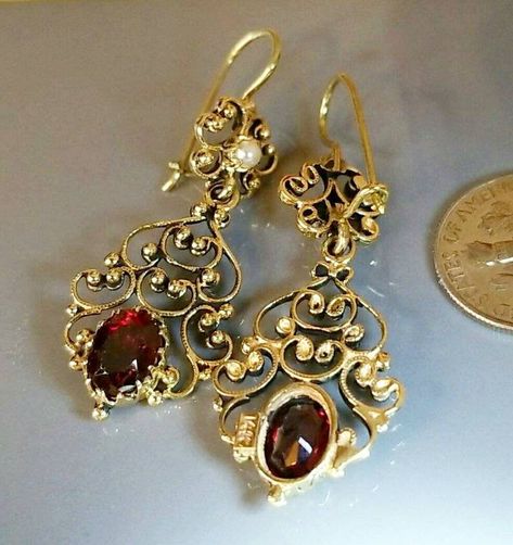 Gorgeous! Pair of marked 14K yellow gold garnet and seed pearl earrings. The earrings are in a dangle style with a 14K yellow gold wire and hook style fastener. Each earring in the pair of earrings measure approximately 1 3/4 inches long and 3/4 of an inch wide. The pair of earrings weigh 8.10 grams. The pair of marked 14K yellow gold garnet and seed pearl earrings come in a quality earring box. The earrings are very beautiful! Antique Gold Earrings, Vintage Gold Earrings, Faberge Jewelry, Antique Gold Jewelry, Traditional Earrings, Jewelry Design Necklace, Jewelry Outfit, Antique Earrings, Victorian Jewelry