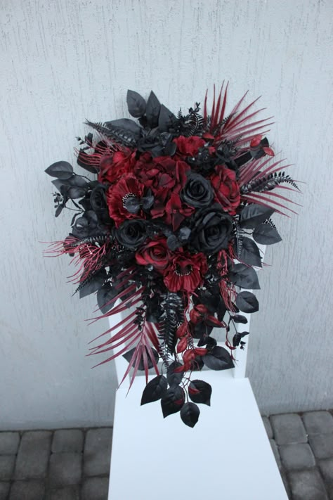 Burgundy black bouquet is a gothic cascading bouquet that embodies a moody and dramatic aesthetic. This silk flower bouquet is a masterpiece of artistry, featuring carefully selected blooms in deep burgundy and black tones, creating a striking contrast that sets a mysterious and enchanting tone for your special day. The cascading design adds an extra touch of elegance, making it a perfect choice for a bride who appreciates the unconventional. This moody bouquet not only serves as a captivating accessory but also enhances the overall atmosphere of your wedding with its unique blend of colors and textures.  ○ Color: burgundy, black ○ Personalization: I can make changes to your wishes ○ Processing time: 1 - 2 weeks ○ Shipping time: 7 - 14 business days NOTE ○ I ship with REGISTERED mail and y Dark Wedding Flowers Bouquet, Spooky Wedding Bouquet, Gothic Bridal Bouquet, Gothic Flower Bouquet, Black And Red Bouquet, Goth Wedding Bouquet, Gothic Wedding Flowers, Gothic Bouquet, Gothic Wedding Bouquet