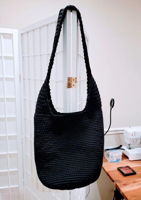 Black crochet boho bag hanging from white room divider. Handmade Crochet Hobo Bag For Everyday Use, Casual Crochet Hobo Shoulder Bag, Black Bohemian Crochet Bag, Beige Crochet Hobo Bag, Everyday Bohemian Hand-knitted Crochet Bag, The Sak Crochet Bag, Hobo Bag Crochet, Boho Crochet Bag, Crochet Hobo Bag