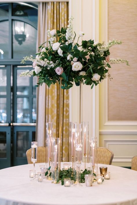 White rose, blush rose, white delphinium, blush spray rose, white freesia, lysimachia - tall gold stand, sand champagne taper candles, gold candlesticks, stemmed hurricanes with floating candles, round table centerpiece Candles Round Table, Tall Round Table, White And Blush Wedding, Round Table Centerpiece, White Delphinium, Gold Candlesticks, White Freesia, Gold Candle Sticks, Tall Centerpieces