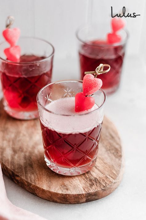 We’re giving the gin fizz a sweet little update, just in time for V-Day. Lulus take on a Cherry Gin Fizz is the perfect cocktail for Valentine's day. Mix up two for you and your special someone, or a pitcher full for your galentines! For a festive touch, add some candy gummy hearts on knotted toothpick skewers. See how to mix up a fun, holiday-themed Valentine cocktail at Lulus.com/blog! #lovelulus Gin Valentines Cocktail, Hearts On Fire Cocktail, Valentine Cocktails Easy, Cocktail Valentines Day, Valentines Themed Cocktails, Valentines Batch Cocktail, Valentine's Day Cocktails, Valentine’s Day Shots, Galentines Drink Alcoholic