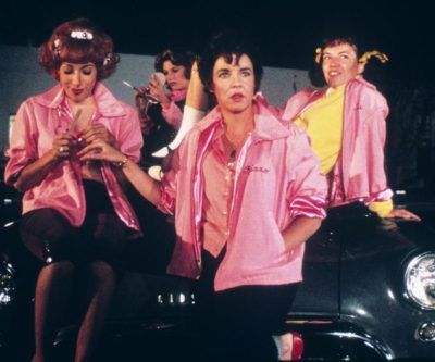 The musical movie, Grease, was filmed in the late 1970s. It’s set in the 50s and is about a wild high school romance between T-Bird Danny Zuko and good girl Sandy Olsson. They have a whirlwind summer romance that ends with a bittersweet farewell. That is until Sandy finds out that she’s not moving back Grease Fashion, Frenchy Grease, Rizzo Grease, Pink Lady Costume, Pink Ladies Grease, Grease Outfits, Grease Movie, Grease Is The Word, Grease Musical