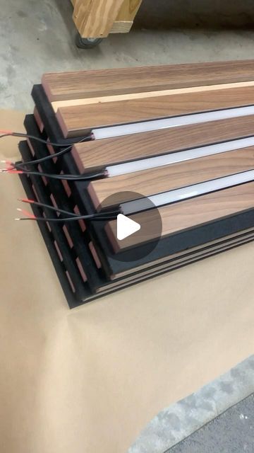 Cory Wasmus on Instagram: "Explore our latest project: walnut slats on black acoustical panels with integrated linear LED lighting. Join us behind the scenes as we prepare this custom wood ceiling and wall project to ship from our workshop in Ohio to destinations across the country! #acousticalpanels #woodwalls #woodceiling #architecturallightingdesign" Wood Panel With Light, Led Slat Wall, Wood Slats Ceiling, Slat Wall Office, Ceiling Panels Ideas, Acoustic Panels Wall Design, Wood Panel Lighting, Slat Wall Ideas, Diy Acoustic Panels