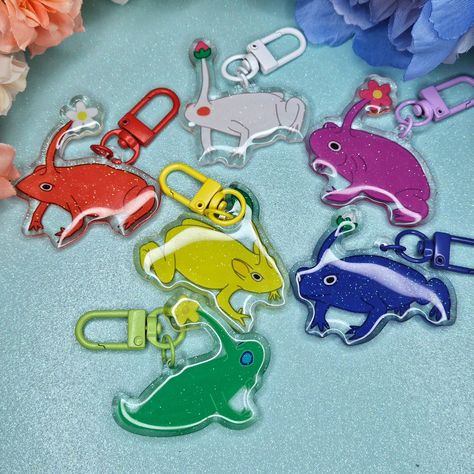 Pik pik frog mystery keychains! All keychains are double sided with glitter and epoxy. Available now! These launched with my shop update and I am so happy with how they turned out. They're all so cute, I think they make the perfect blind bag keychain. You can't lose they're all adorable! Which one is your favorite? I really like the purple one 💜 . . . #pikmin #pikminbloom #pikmin4 #pikminfanart #frogcore #frogvibes #frogmerch #froglove #frogshop #frogartwork #commonrainfrog #stickerartist... Bag Keychain, Blind Bag, I Am So Happy, Blind Bags, Which One Are You, The Purple, So Happy, Keychains, So Cute