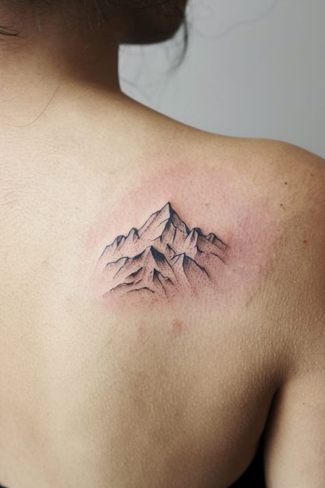 A tiny mountain range tattoo on your shoulder symbolizes strength, adventure, and perseverance. This minimalist design adds a subtle reminder of your love for the great outdoors. Perseverance Tattoo Symbols, Wilderness Tattoo Women, Perseverance Tattoo, Arkansas Tattoo, Whale Tail Tattoo, Wilderness Tattoo, Mountain Range Tattoo, Olive Branch Tattoo, Compass Rose Tattoo