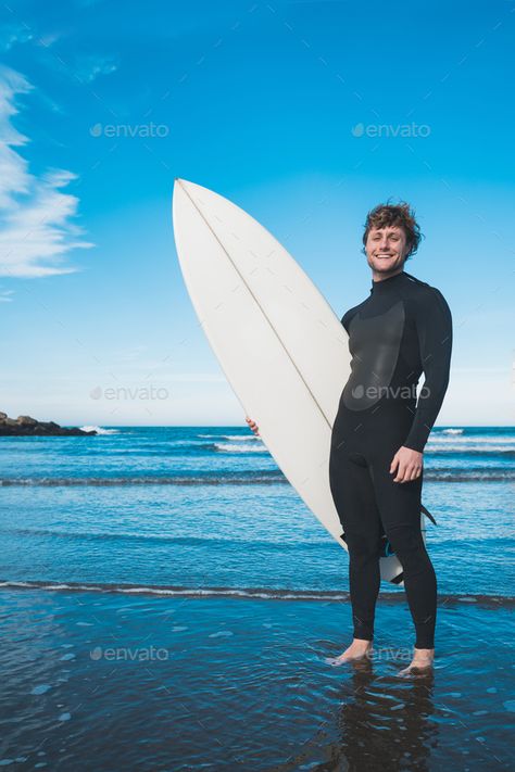 Surfer standing in the ocean with his surfboard. by megostudio. Young surfer standing in the ocean with his surfboard in a black surfing suit. Sport and water sport concept. #Sponsored #megostudio, #Young, #surfer, #surfboard Posing With Surfboard, Surfing Poses Reference, Surfer Holding Surfboard, Man With Surfboard, Holding Surfboard Pose, Surfer Pose Reference, Surfer Reference, Beach Reference Pose, Surfing Pose Reference