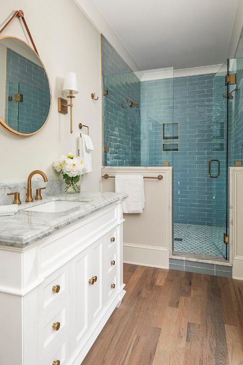 Sea blue shower walls create a spa like feel to a walk in shower featuring brass shower fixtures and a frameless glass door. Blue Shower Tile, Beach House Bathroom, Shower Wall Tile, Shower Fixtures, Bathroom Redesign, Blue Tile, Bathroom Remodel Designs, Bathroom Remodel Shower, Bathroom Redo